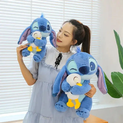 Person holding two Disney Stitch plush dolls with ducks